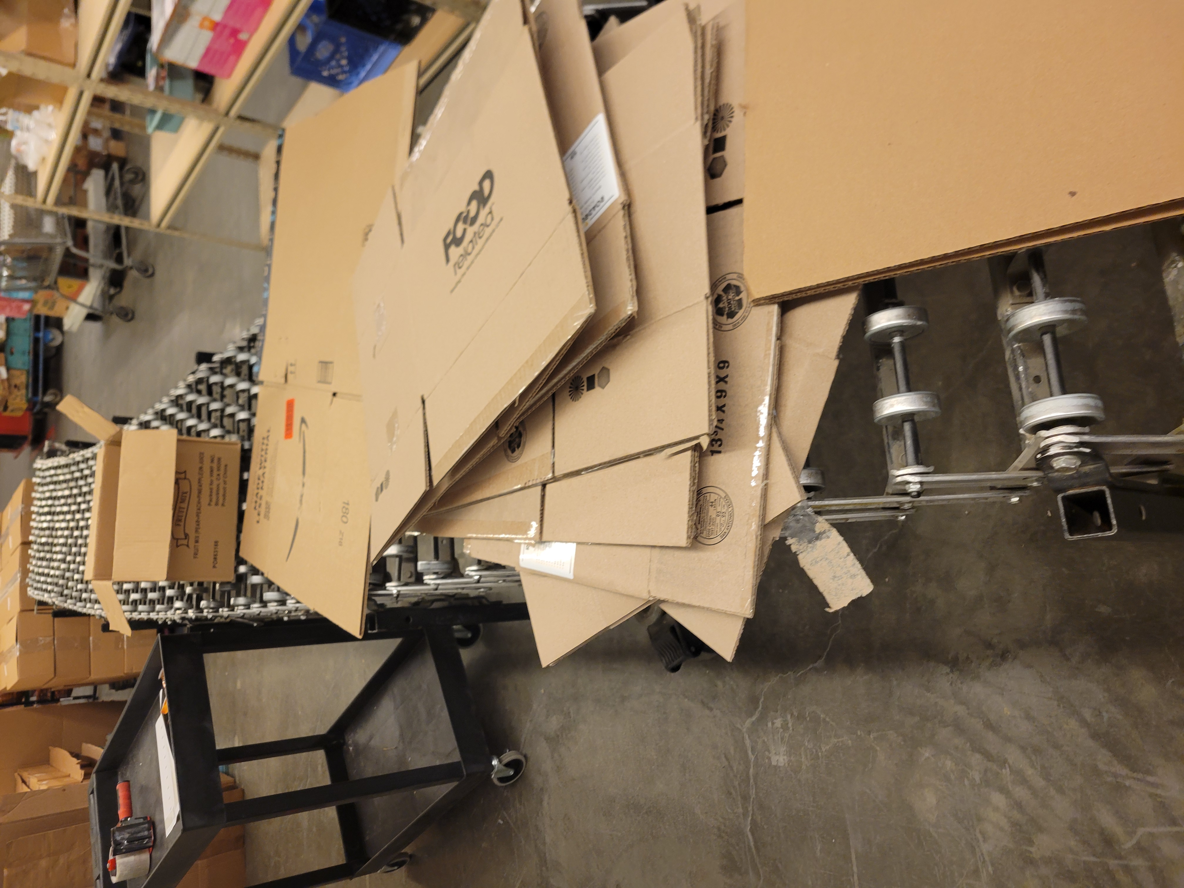 Row of boxes scattered across a conveyor belt.